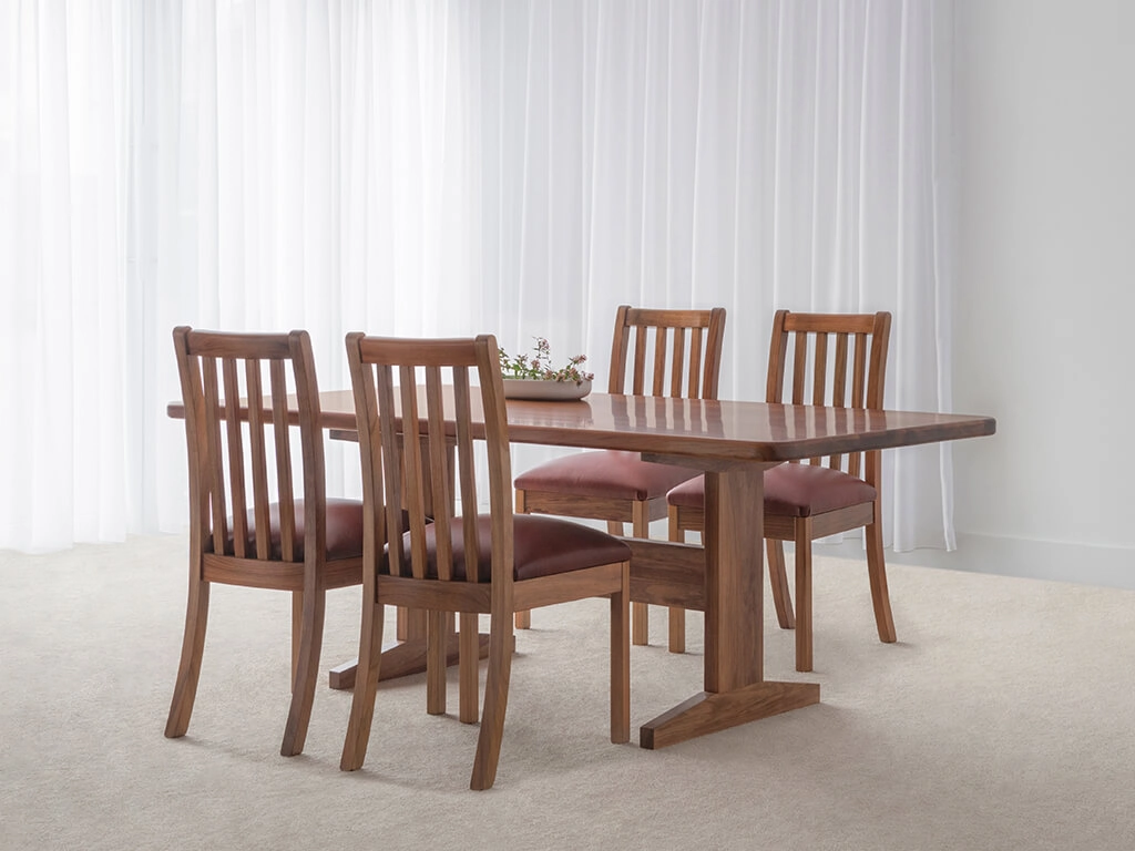 spacious dining table with modern pedestal base and curved corners made in custom tone hardwood timber