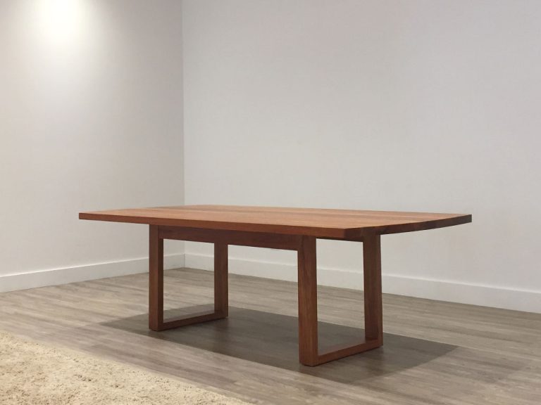 contemporary dining table with curved top and open base in solid timber