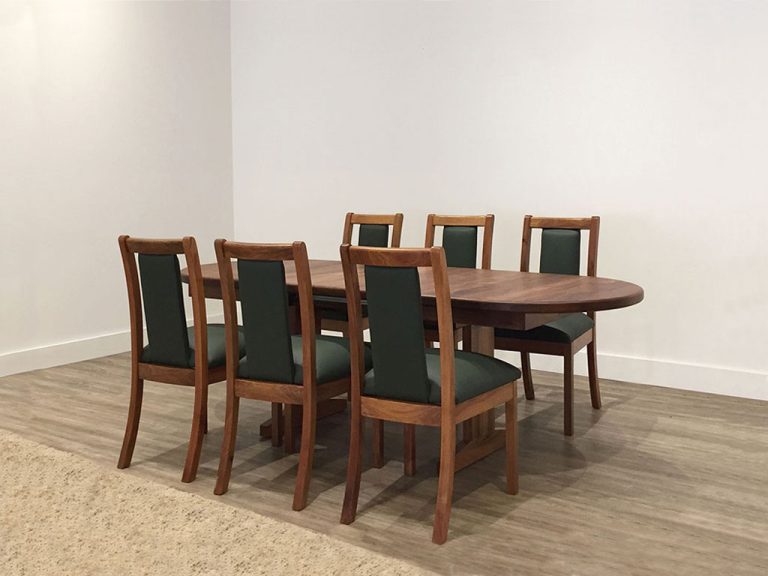 traditional timber dining suite in blackwood timber with green leather high back chairs