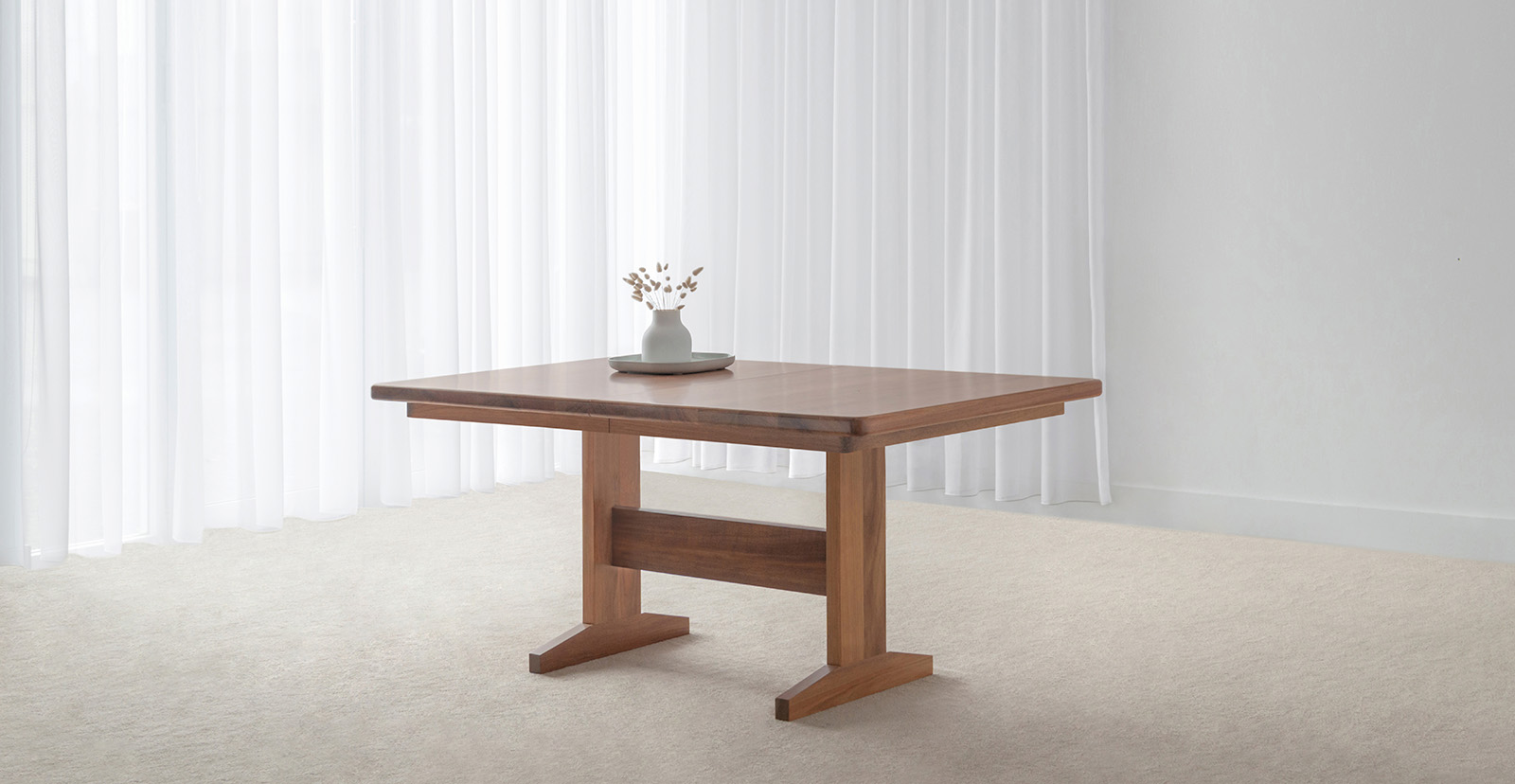 spacious dining table with modern pedestal base and curved corners made in custom tone hardwood timber