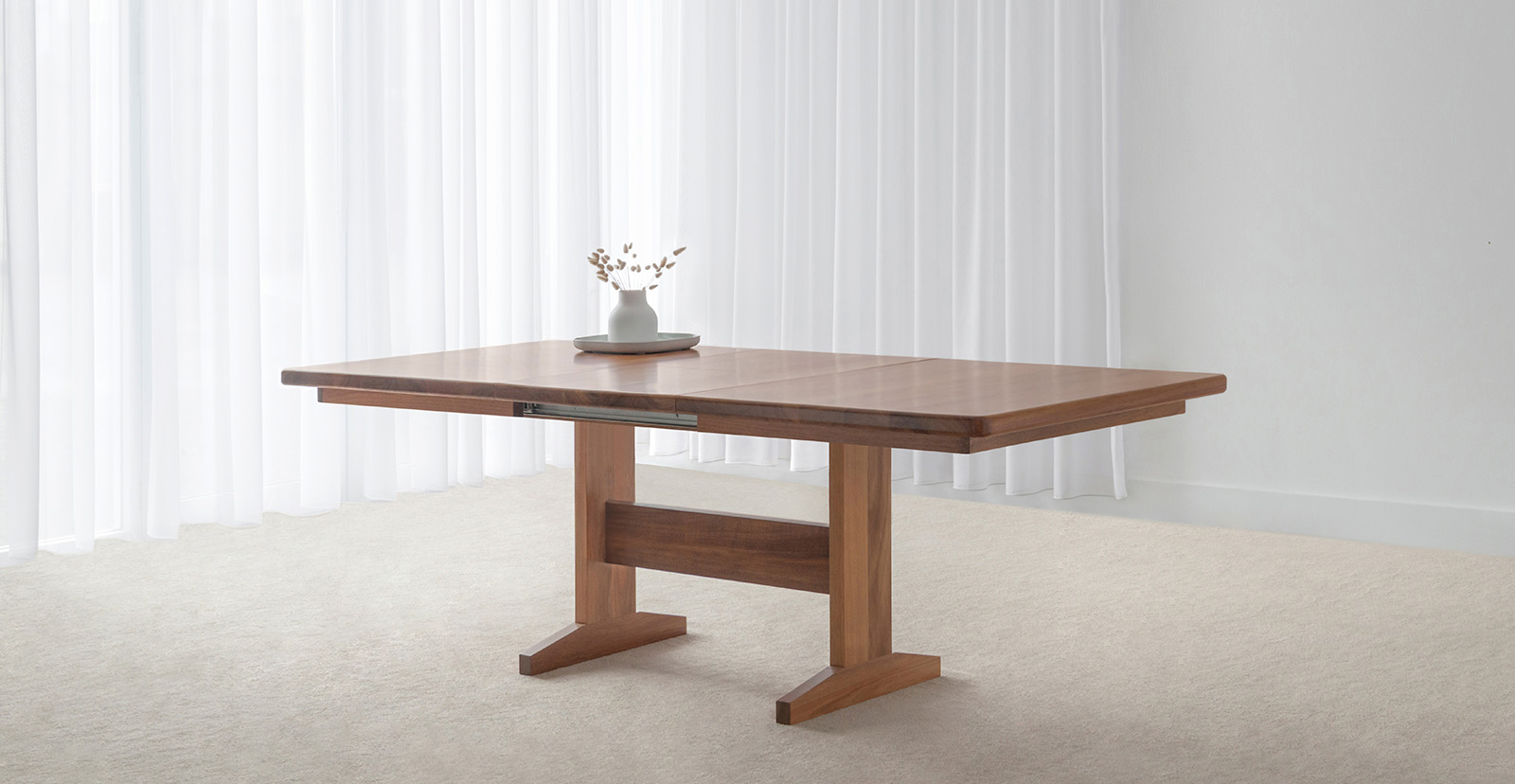 spacious dining table with modern pedestal base and curved corners made in custom tone hardwood timber