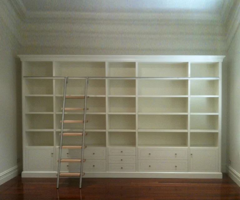 custom made large white bookshelf with stepping ladder, generous shelving and drawers below