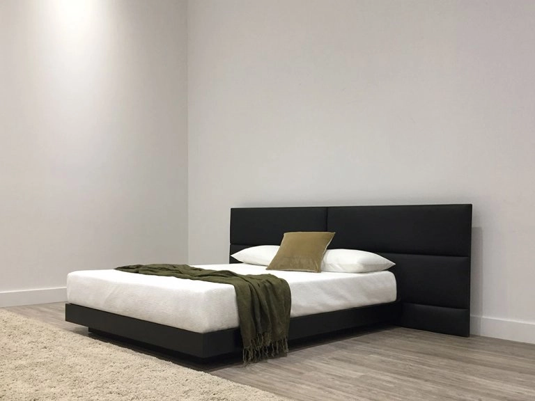 large leather upholstered bed with black leather panels and black timber floating base