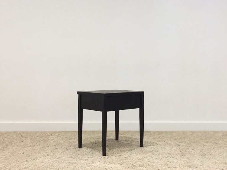 black bedside table with single drawer and tapered legs