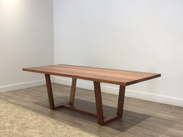 10 seater dining table with angular legs and footrail made in blackwood